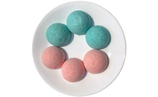 Three blue and three pink homemad bath bombs on a plate