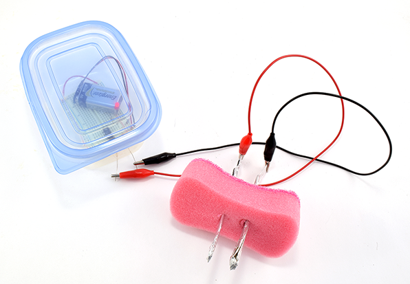 An example of a modified soil moisture circuit made with kit components, a sponge, and a plastic container