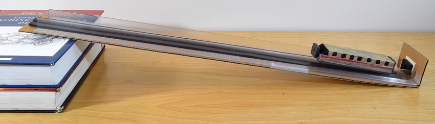 A maglev track is placed on an incline by placing a stack of books under one end of the track 