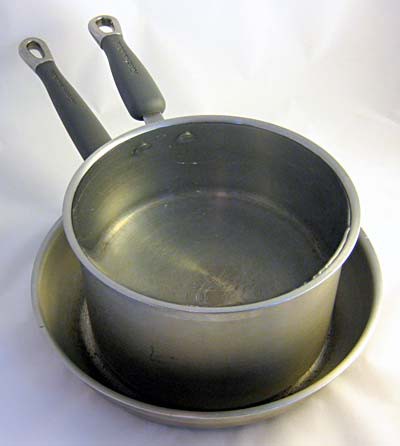 A pot filled with water placed inside of a pan