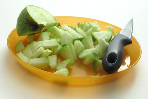A knife slices an apple into small pieces