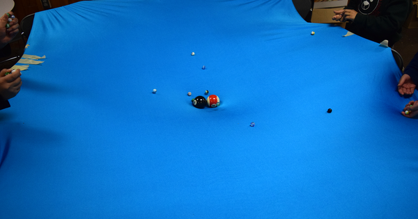 Piece of fabric with pool ball and marbles representing planets