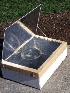 The top of a solar-oven is opened revealing a mirrored finish on the inside walls