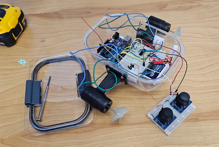 Electronics for an Arduino ROV placed inside a clear plastic food storage container 