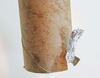 A strip of aluminum foil exits the end of a cardboard tube and is folded over the rim