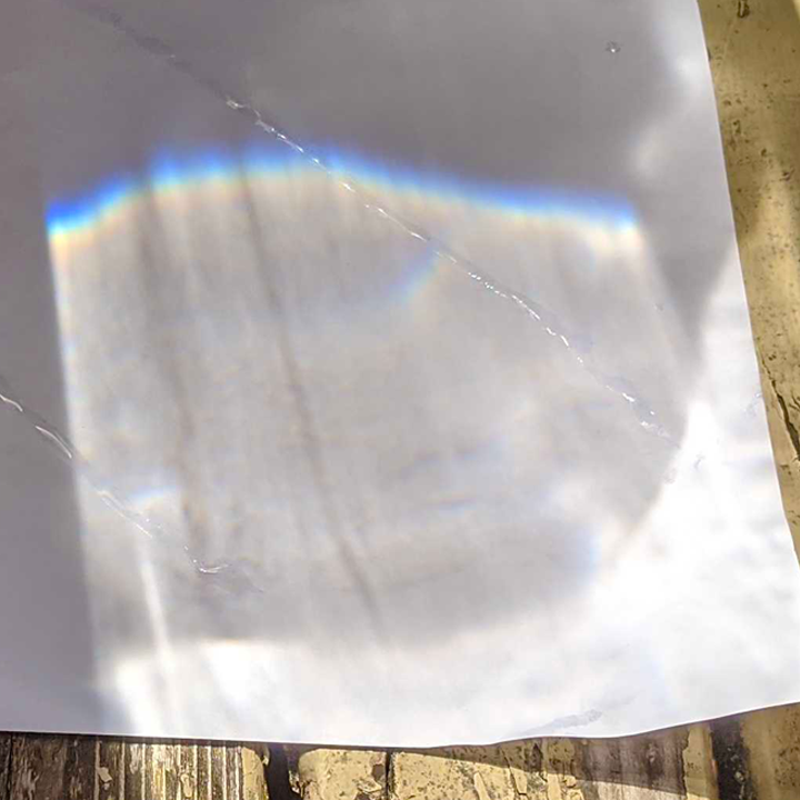 Rainbow science experiment created using a bucket of water and paper for light science