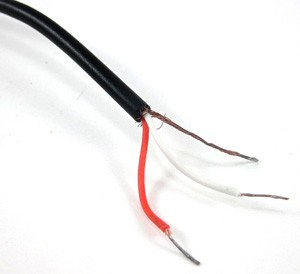 Three wires are exposed from the stripped end of a 3.5 millimeter audio cable