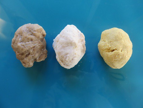 Three balls of dough made from wheat flour and two different types of gluten free flour