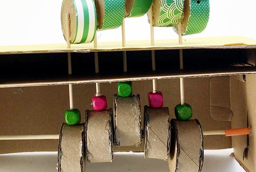  The inside of the caterpillar automaton. There are five skewers each with a bead on its end that rests on a cylinder.  
