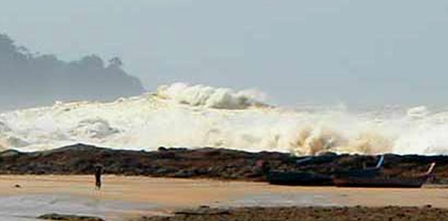 Photo from a beach where large foaming waves approach the shoreline