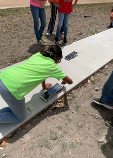 Student working on solar sprint car outside