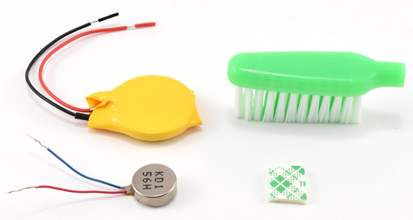 A coin cell battery, toothbrush head, vibration motor, and double sided tape