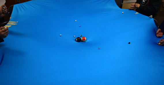 Piece of fabric with pool ball and marbles representing planets