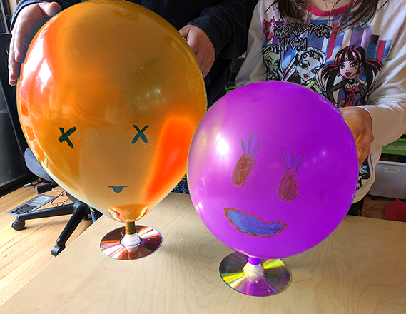Two hovercraft made from balloons and compact discs