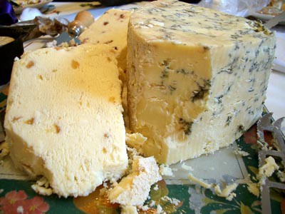 Cross section of cheese cut open with veins of brown and black mold