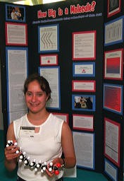 A student posing in-front of a vertical overlap display board