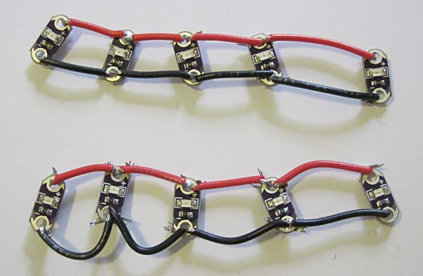 Two sets of five LEDs that have red and black wires connecting the positive and negative terminals