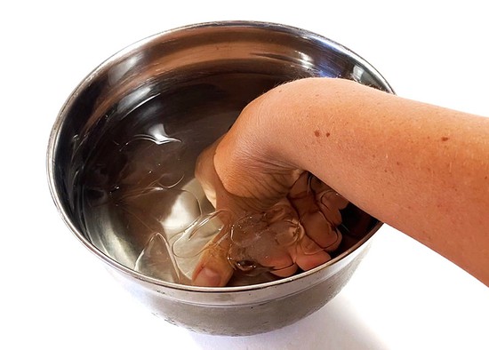  A hand submerged in an ice-bath. 