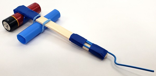 The trebuchetâ€™s popsicle stick arm with a counterweight on one end and a paperclip hook on the other end. 