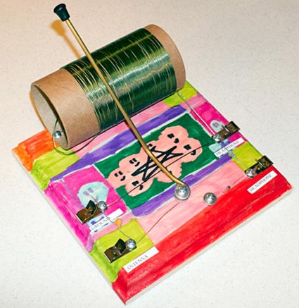 The wooden base of a homemade crystal radio decorated with paint