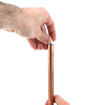 A cylindrical neodymium magnet is prepared to be dropped through the center of a narrow copper pipe