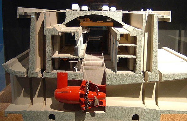 Photo of a scale model of the inside of the Rance tidal barrage, a turbine sits at the bottom of a tunnel