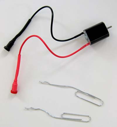 Motor with two leads next to two bent paperclips
