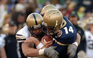 two football players colliding with their helmets 