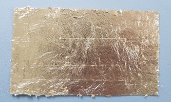 Final vinyl sheet and temporary tattoo backing after three layers of metal leaf. 