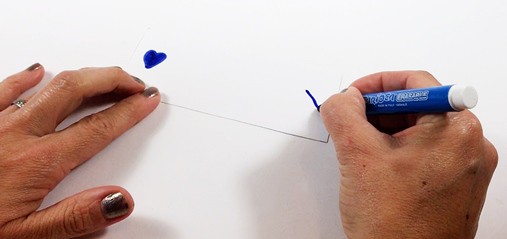 2 inch by 5 inch paper card with a heart drawn on the left end and an X on the right end.