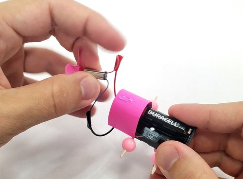 piece of cardstock glued to both sides of battery pack to form an arch 