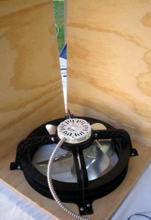 Wood panels are glued around the sides of a fan mounted in a wooden panel