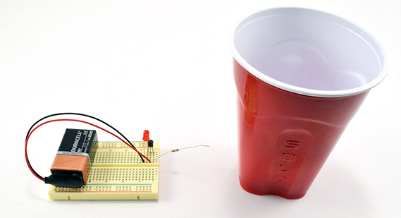 physics experiments electricity A battery and simple breadboard circuit that creates an electric field detector with an LED that goes off when an electric field is present
