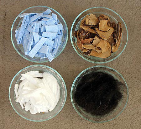 Four bowl contain absorbant materials, shop towels, coconut husks, hair, and cotton