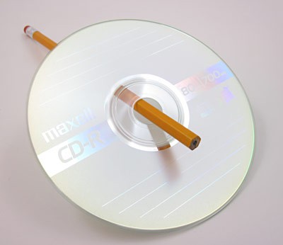 A pencil inserted through the center hole of a CD