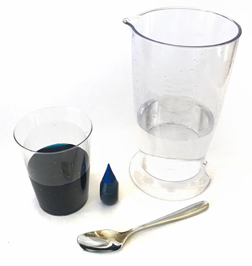 A cup of blue water, blue food dye, a cup of clear water and a spoon
