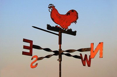 Metal chicken weather vane against a blue sky.