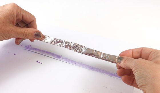 An aluminum strip is glued on top of a paper strip.
