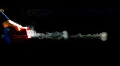 Two rings of smoke are shooting out of a vortex cannon made from a plastic cup.