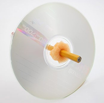 A pencil and piece of sponge are inserted through the center of a CD