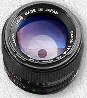 Photo of a camera lens where a small octagonal hole can be seen behind the glass of the lens