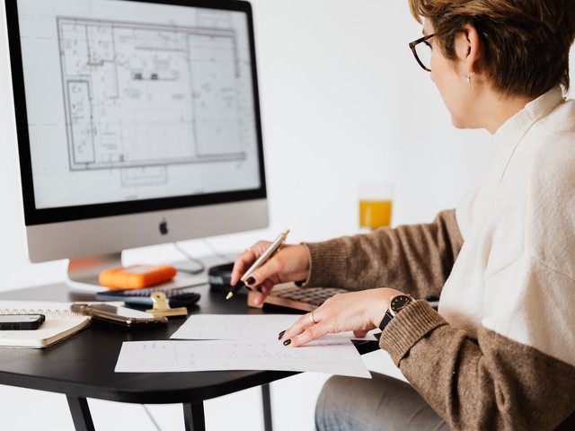 people sitting at table looking at construction documents