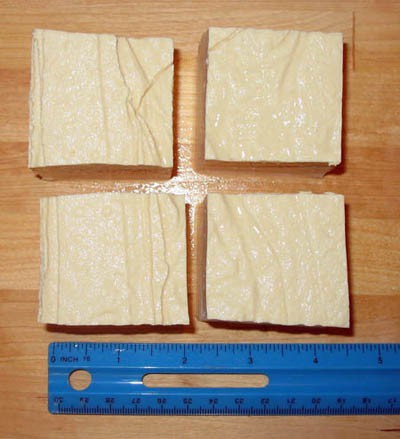 A block of white tofu is cut into four equal cubes