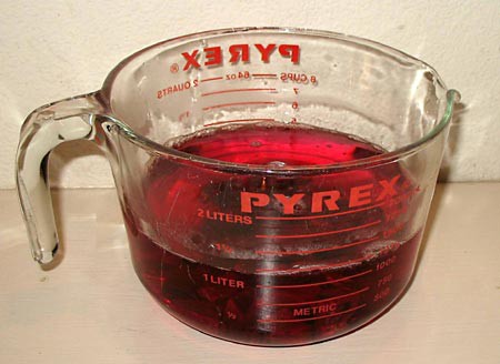 Glass measuring cup filled with a red liquid