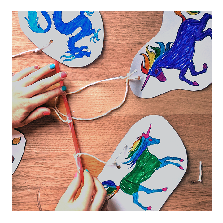 Kid arranging mobile elements on homemade mobile to balance them - Awesome Summer Science Experiments