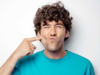 man in blue shirt with curly hair making a funny face