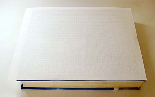 A sheet of graph paper taped to a text book cover