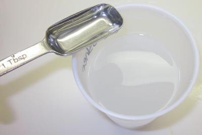 A tablespoon of vinegar is added to a plastic cup