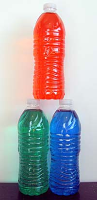 Three bottles filled with colored water are stacked in the shape of a triangle