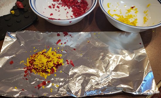 Crayon shavings in a layered pile on aluminum foil.